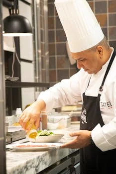 chef preparing wings in restaurant kitchen